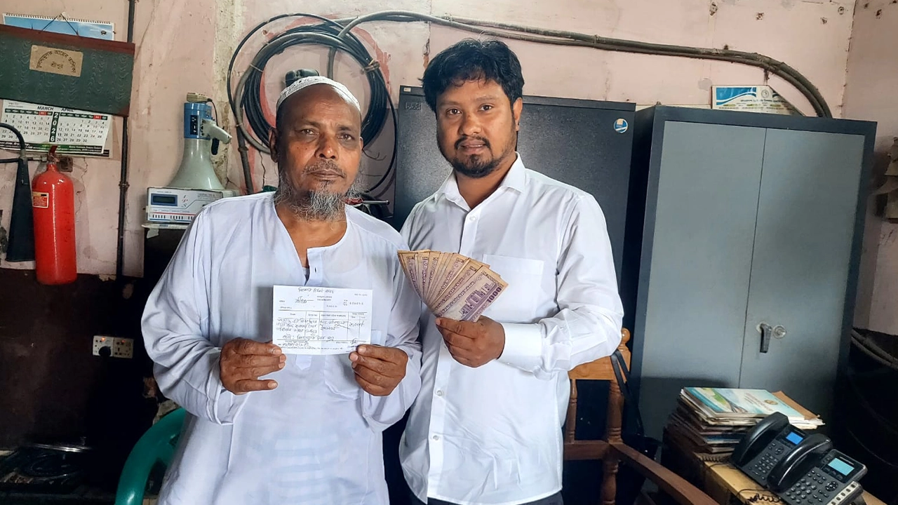 মফিজুল ইসলাম (বাঁয়ে) বুঝিয়ে দেন বিনা টিকিটে ভ্রমণের টাকা। ছবি: এশিয়া পোস্ট