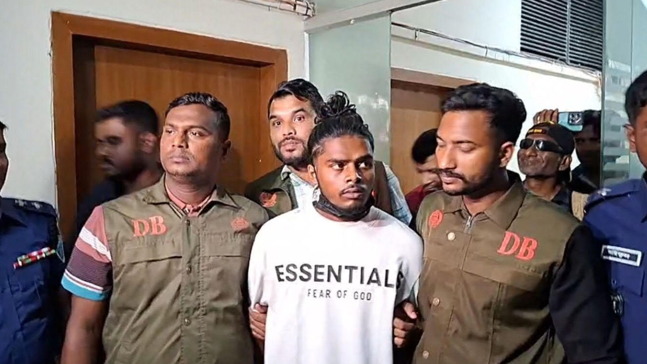 পুলিশ সদস্যের সঙ্গে রিমান্ডপ্রাপ্ত মোহাম্মদুল হক প্রকাশ ওরফে কাকা তারেক। ছবি : এশিয়া পোস্ট