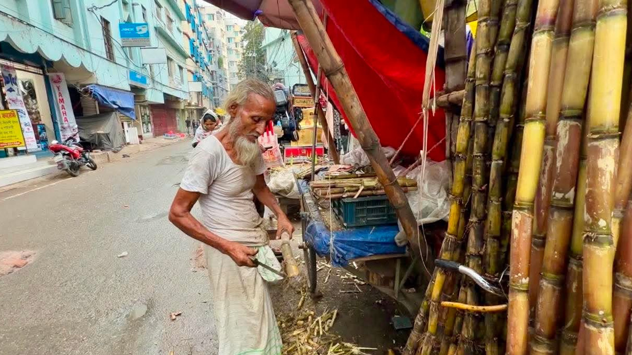 নিজ হাতে আখ পরিষ্কার করছেন হামিদ হাওলাদার। ছবি: এশিয়া পোস্ট