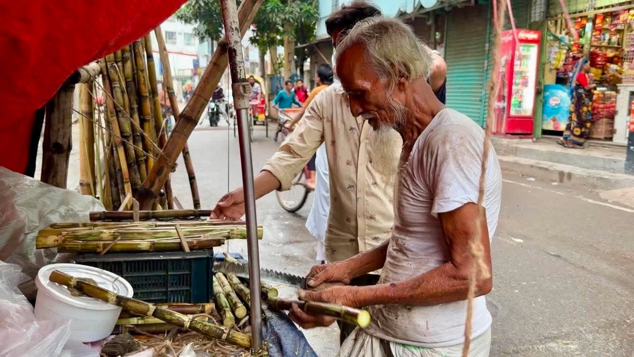 হামিদ হাওলাদারের কাছ থেকে আখ কিনছেন এক পথচারী। ছবি: এশিয়া পোস্ট