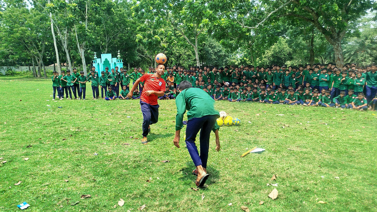 কালীগঞ্জের কোলা বাজার ইউনাইটেড হাইস্কুল মাঠে শিক্ষার্থীদের সামনে ফুটবল নিয়ন্ত্রণের কৌশল প্রদর্শন করেন আব্দুল হালিম। ছবি: এশিয়া পোস্ট