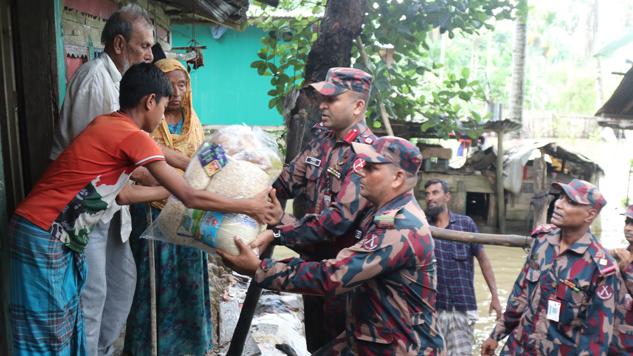 বন্যার পানি ডিঙিয়ে ত্রাণ বিতরণ করছেন বিজিবি সদস্যরা। সোমবার সকালে রাঙামাটির বরকল উপজেলায়। ছবি: এশিয়া পোস্ট