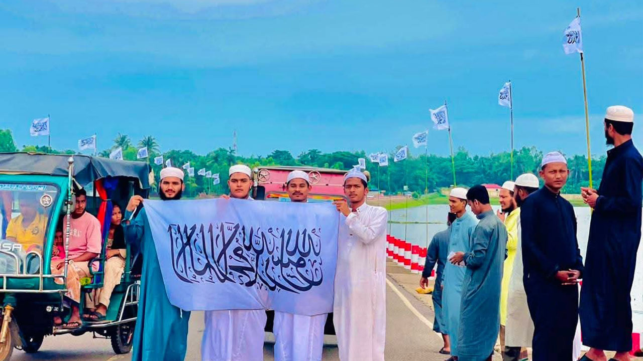 শাহপরীর দ্বীপ সড়কে পতাকা হাতে দাঁড়িয়ে কয়েকজন যু্বক। ছবি: সংগৃহীত
