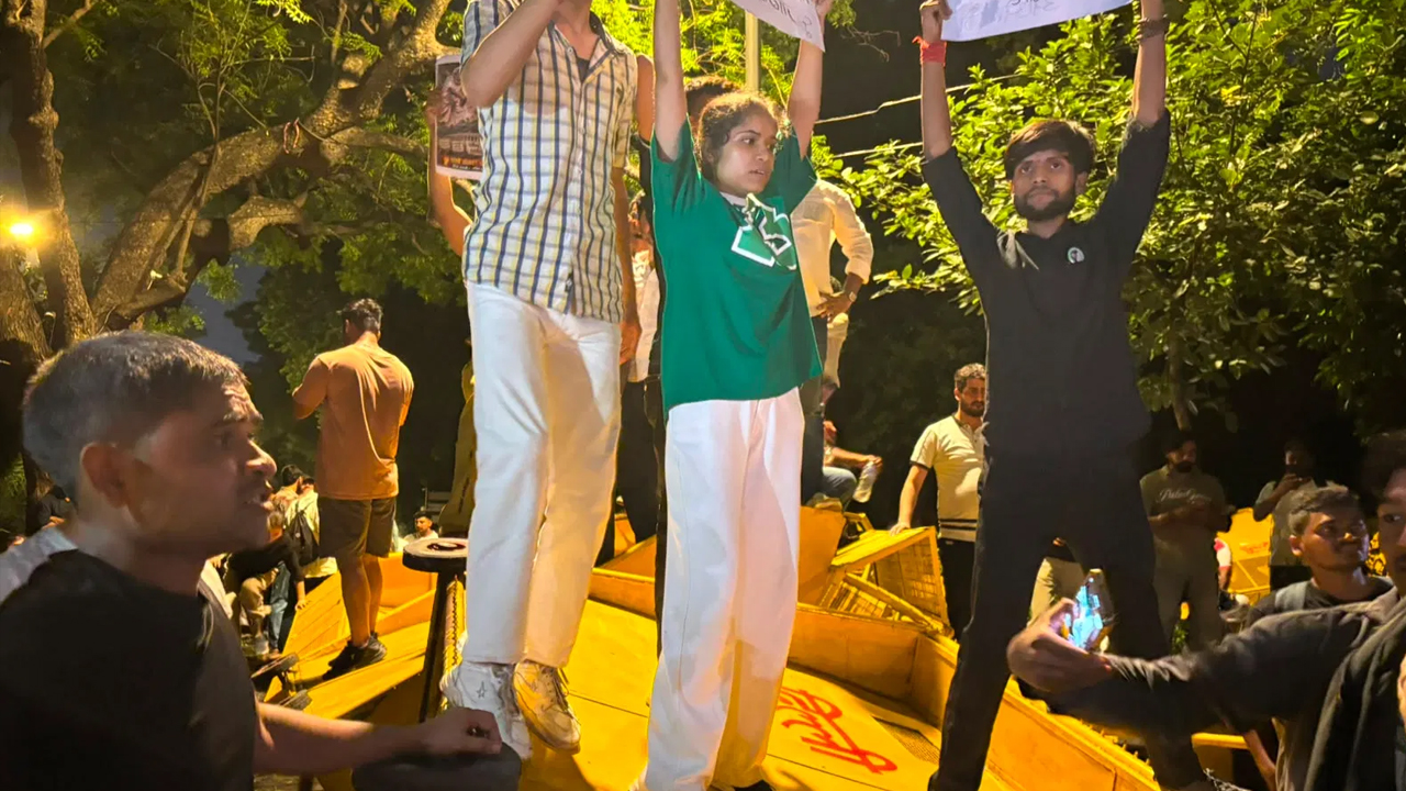 রাতে প্ল্যাকার্ড হাতে পুলিশের ব্যরিকেডের ওপর থেকে আন্দোলনকারীদের স্লোগান দেওয়ার দৃশ্য। ছবি: সংগৃহীত