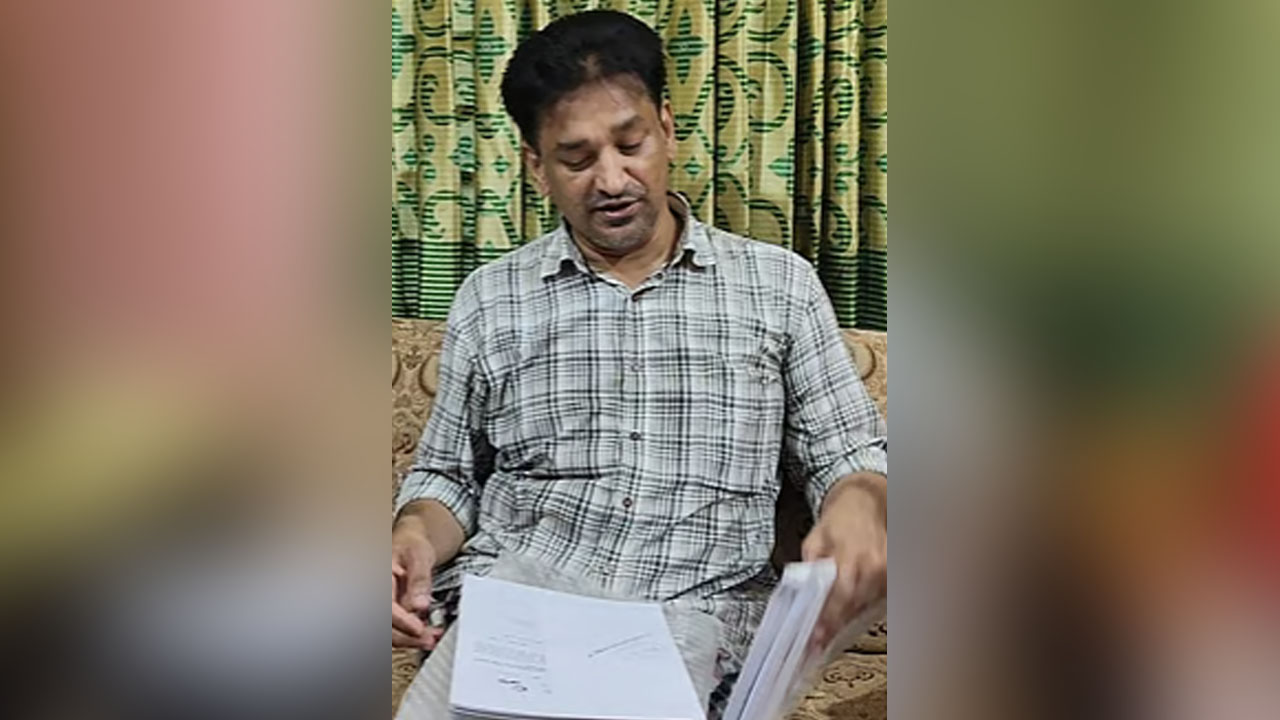 কাগজপত্র হাতে শাহেদের বাবা শরীফুল ইসলাম। ছবি : এশিয়া পোস্ট