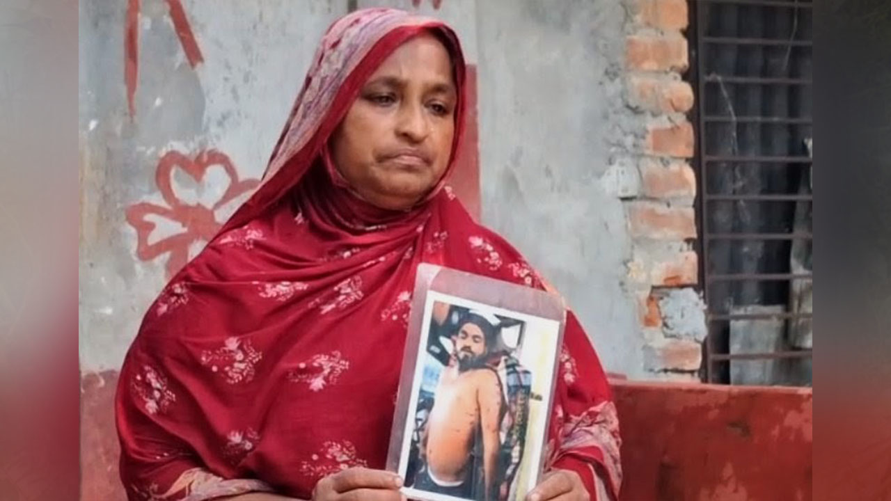 সন্তানের ছবি হাতে মেহেদী হাসানের মা। ছবি: এশিয়া পোস্ট