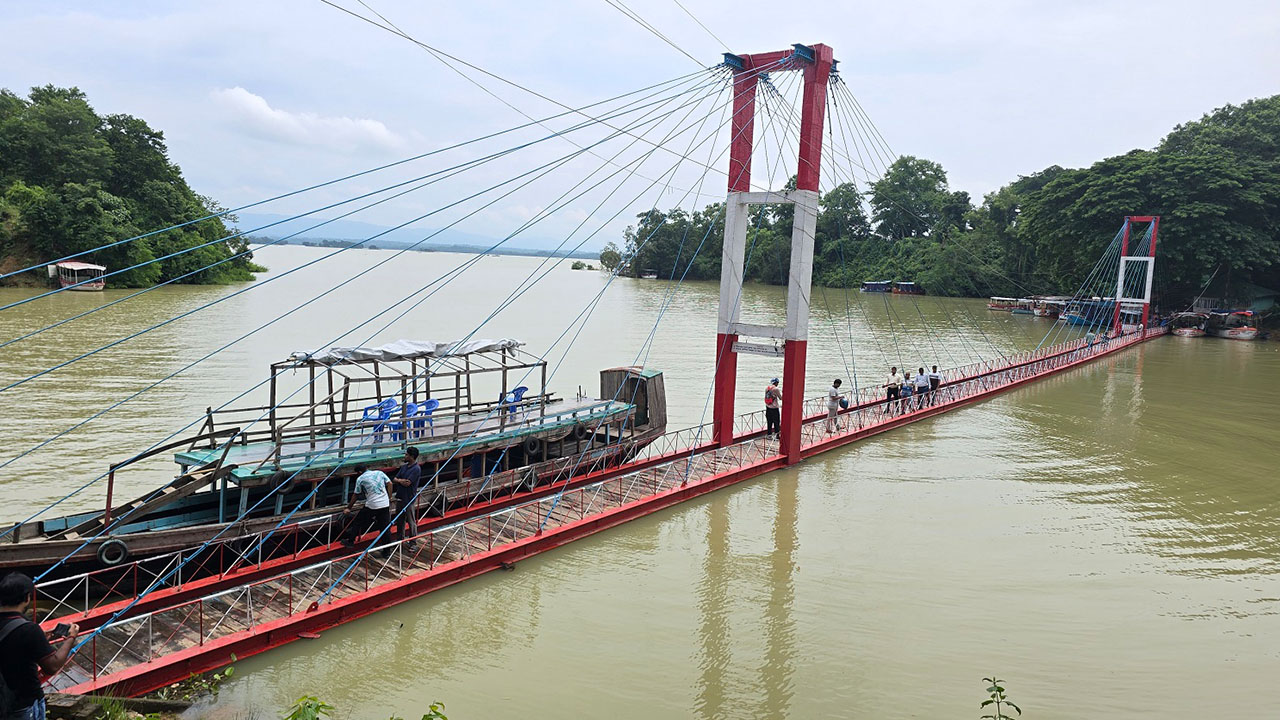 শুক্রবার সকাল থেকে পানি নামতে শুরু করায় রাঙামাটির ঝুলন্ত সেতুটির পাটাতন ভেসে ওঠে। ছবি : এশিয়া পোস্ট