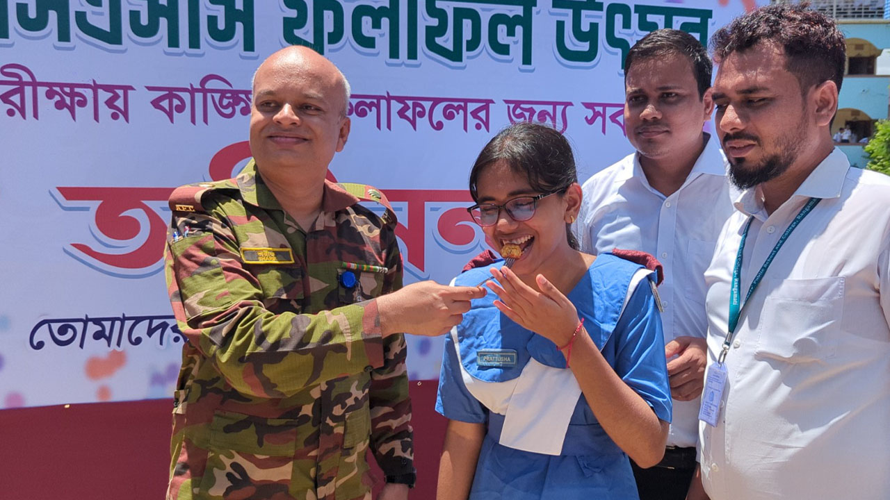 এক শিক্ষার্থীকে মিষ্টিমুখ করিয়ে শুভেচ্ছা জানাচ্ছেন বিদ্যালয়ের অধ্যক্ষ মেজর মোহাম্মদ শরিফুল ইসলাম। ছবি: এশিয়া পোস্ট