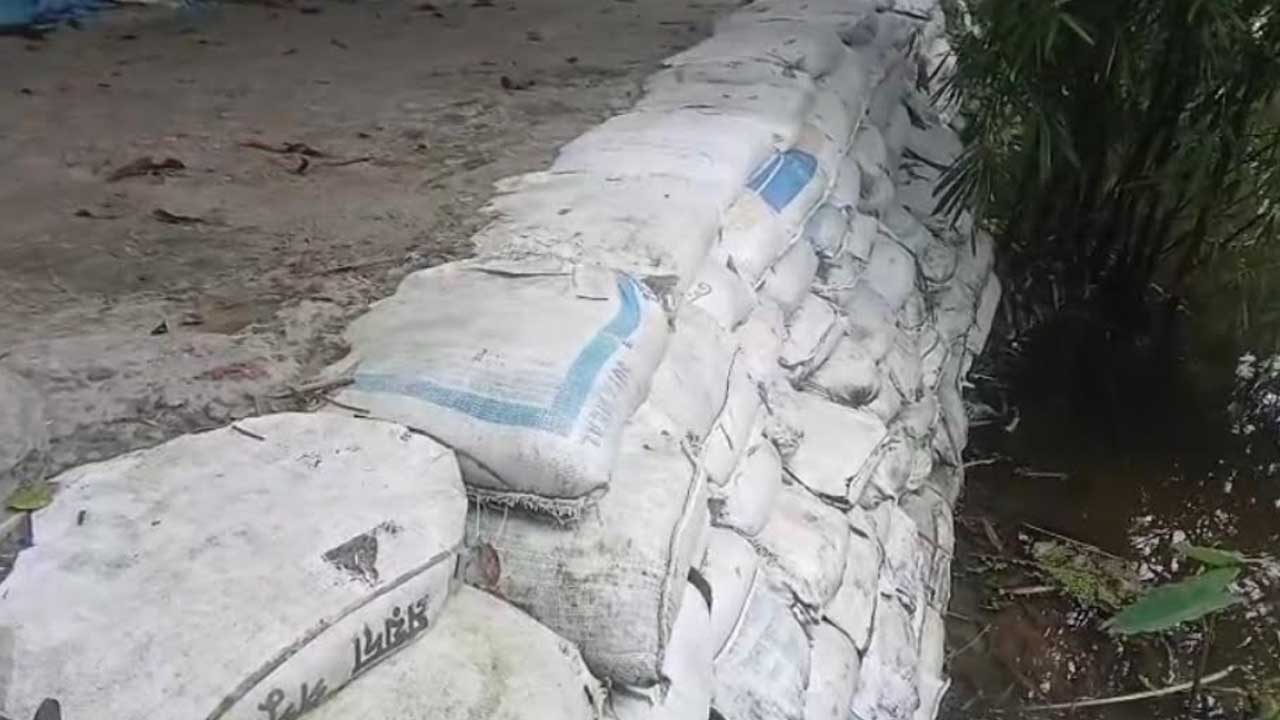 এলাকায় নিজ খরচে বালুর বস্তা দিয়ে গ্রামীণ রাস্তা ভাঙনমুক্ত ও টেকসই করছেন প্রবাস ফেরত আতিকুর। ছবি: এশিয়া পোস্ট